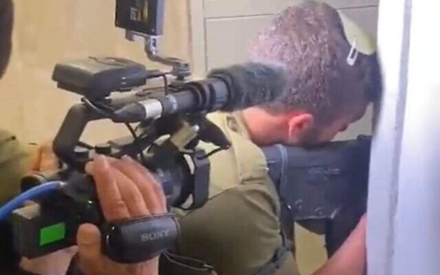 A Channel 12 cameraman and reporter follow an IDF soldier into a home in Tel Aviv during the manhunt for the attacker on April 7, 2022. (Screen capture/Channel 12)