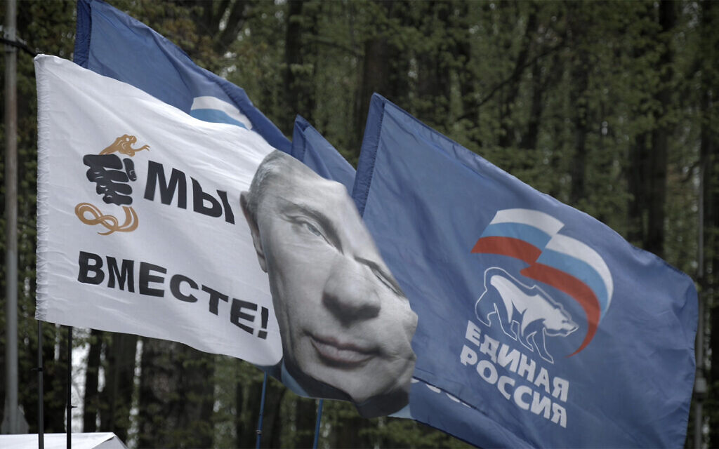 Flags flying in Yelnya, Russia, as seen in Dmitry Bogolyubov's documentary film, 'Town of Glory.' The flag with President Vladimir Putin and a fist crushing a snake says, 'We are united!' and the flag with the bear says, 'United Russia,' the name of Putin's ruling political party. (Courtesy of First Hand Films)