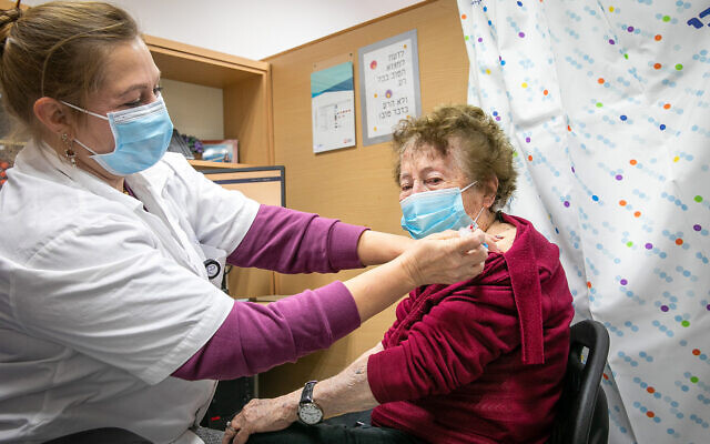 An elderly woman receives a dose of the COVID-19 vaccine at a temporary Maccabi health care center in Rehovot, January 10, 2022. (Yossi Aloni/Flash90)