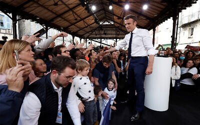 Centrist candidate and French President Emmanuel Macron shakes hands with supporters after a campaign rally Friday, April 22, 2022 in Figeac, southwestern France. (Benoit Tessier, Pool via AP)