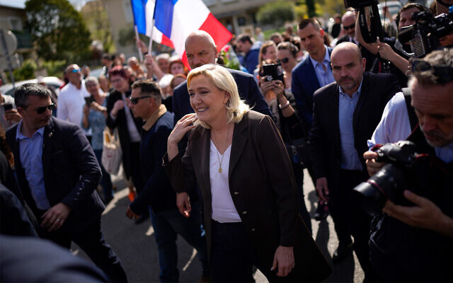 French far-right politician Marine Le Pen, center, arrives during a campaign tour in Pertuis, southern France, April 15, 2022. (AP Photo/Daniel Cole)