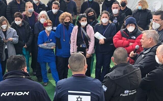 Health Minister Nitzan Horowitz, with microphone, speaking to staff of Israel's field hospital near Lviv, Ukraine on April 4, 2022, in a handout photo provided by the Health Ministry. (Sharon Yaniv/Health Ministry)