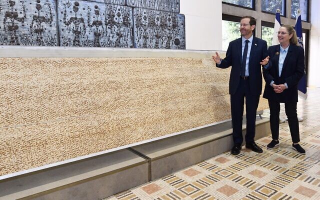 President Herzog and First Lady Michal Herzog are presented with Israel's biggest matzah at the President's House in Jerusalem, April 10, 2022. (Haim Zach/GPO)