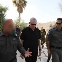 Defense Minister Benny Gantz, center, tours a Border Police base in the West Bank, with the commander of the Border Police, Amir Cohen, right, on April 19, 2022. (Elad Malka/Defense Ministry)