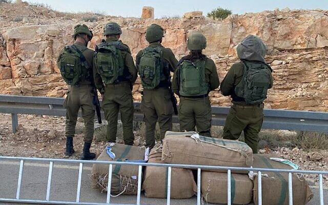 Troops stand next to drugs seized during a smuggling attempt on the Egypt border, on April 23, 2022. (Israel Defense Forces)