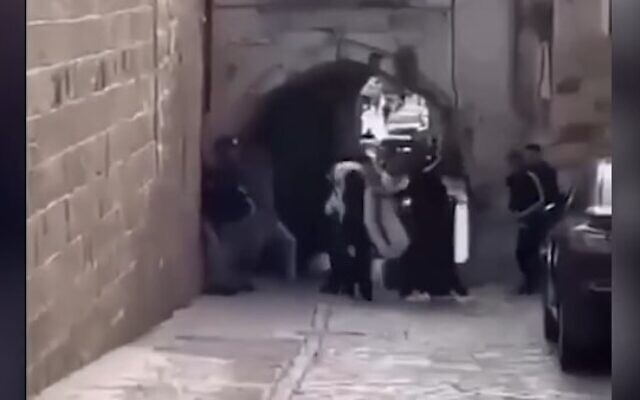 A group of ultra-Orthodox Jews attacked by a mob on their way to the Western Wall in Jerusalem's Old City, on April 17, 2022. (Screenshot)