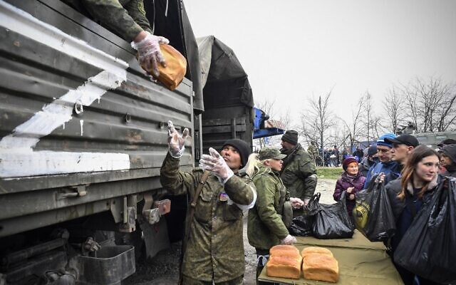 Russian soldiers and volunteers distribute bread in Mariupol on April 12, 2022. (Alexander NEMENOV / AFP)