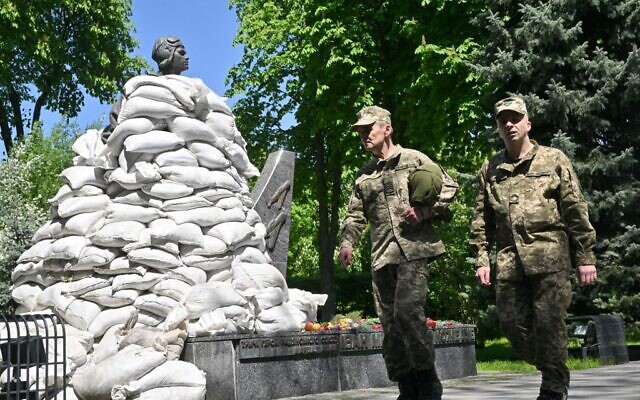 Ukrainian servicemen walk past the sandbagged monument to World War II hero Air Marshal of Soviet Army Ivan Kozhedub, in Kyiv on May 9, 2022, during Victory Day, the 77th anniversary of the defeat of Nazi Germany by the forces of the Soviet Union. (Sergei SUPINSKY / AFP)