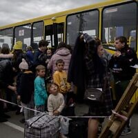 In this file photo from April 29, 2022, families from Russian occupied territories arrive in a humanitarian convoy at a registration and processing center for internally displaced people in Zaporizhzhia. (Ed Jones/AFP)