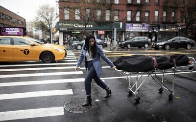 A funeral service manager transports a body to the funeral home in the Harlem neighborhood of New York City,  April 24, 2020. (Johannes EISELE / AFP)
