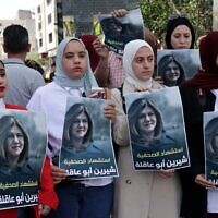 Palestinians hold posters displaying veteran Al Jazeera journalist Shireen Abu Akleh, who was shot dead during clashes between Israeli troops and Palestinian gunmen as she covered a raid in Jenin on May 11, 2022. (HAZEM BADER / AFP)