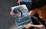Palestinians hold a poster displaying veteran Al Jazeera journalist Shireen Abu Aqleh, who was shot dead as she covered an IDF raid on the West Bank's Jenin refugee camp on May 11, 2022, in the West Bank city of Hebron. The poster reads in Arabic, "the Martyrdom of Journalists Shireen Abu Aqleh". (HAZEM BADER / AFP)