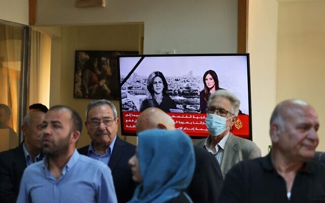 People gather at the Al Jazeera offices in the West Bank city of Ramallah on May 11, 2022 following the killing of veteran journalist Shireen Abu Akleh who was shot dead during clashes between Israeli troops and Palestinian gunmen as she covered an Israeli raid on the West Bank's Jenin refugee camp. (Abbas Momani/AFP)