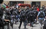Police and mourners are seen during the funeral procession of Al Jazeera journalist Shireen Abu Akleh in Jerusalem, on May 13, 2022. (AHMAD GHARABLI/AFP)