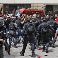 Police and mourners are seen ahead of the funeral of Al Jazeera journalist Shireen Abu Akleh in Jerusalem, on May 13, 2022. (AHMAD GHARABLI/AFP)