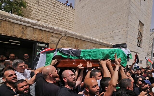 Palestinian mourners carry the casket of Al Jazeera journalist Shireen Abu Akleh out of a hospital, before being transported to a church and then her resting place, in Jerusalem, on May 13, 2022 (AHMAD GHARABLI / AFP)