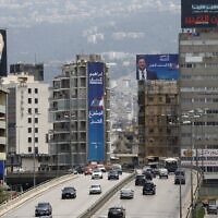 Electoral billboards overlook a bridge in Lebanon's capital Beirut, on May 14, 2022, on the eve of parliamentary elections. (LOUAI BESHARA / AFP)