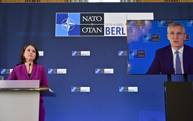 NATO Secretary-General Jens Stoltenberg (on video screen) addresses an informal meeting of NATO foreign ministers on the conflict in Ukraine, as German Foreign Minister Annalena Baerbock listens, on May 15, 2022 ,in Berlin. (John MacDougall/AFP)