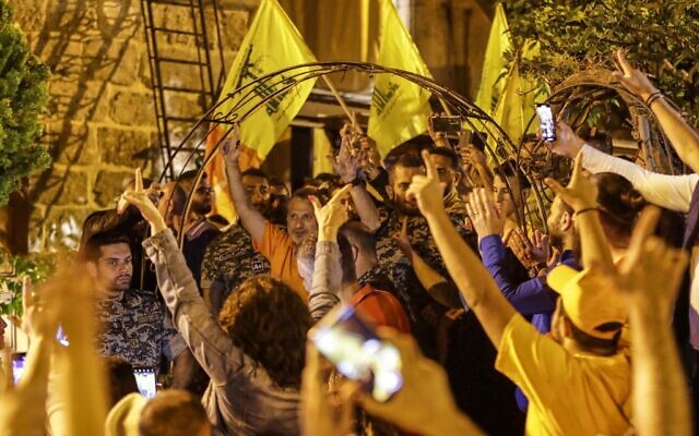 Lebanon's former foreign minister and parliamentary candidate Gibran Bassil (C) meets supporters waving the yellow flags of the Lebanese Hezbollah at his residence after the end of voting in the parliamentary election in the northern city of Batroun early on May 16, 2022. (Ibrahim Chalhoub / AFP)