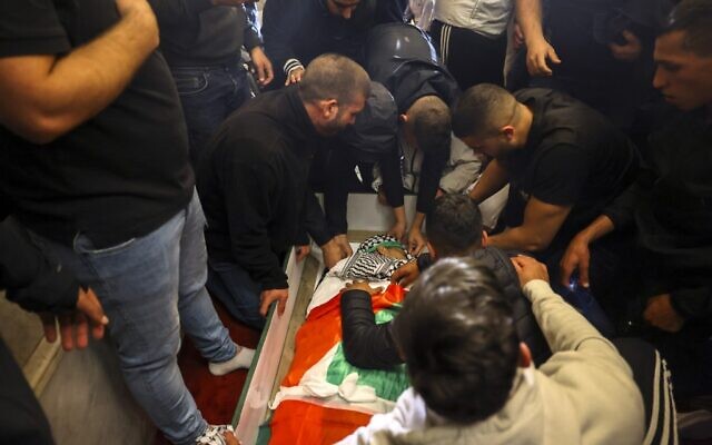 Palestinian mourners surround the body of Walid al-Sharif who died of wounds suffered during clashes with Israeli police at Jerusalem's Temple Mount, on May 16, 2022. ( AHMAD GHARABLI / AFP)