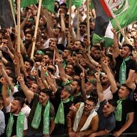 Palestinian students supporting the Hamas terror group wave flags as they attend a debate ahead of student council elections at Birzeit University on the outskirts of Ramallah in the West Bank, on May 17, 2022. (Photo by ABBAS MOMANI / AFP)