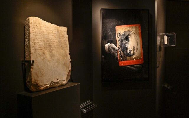 A stele of a Jewish slave, dated circa 300-250 BCE (L), is displayed in the exhibition "Stone Paths - Stories set in Stone: Jewish Inscriptions in Greece," at the Jewish Museum of Greece, in Athens, May 17, 2022. (Louisa Gouliamaki/AFP)
