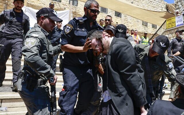 Ultra-Orthodox Jews scuffle with the police as they try to enter the gravesite of Rabbi Shimon Bar Yochai at Mount Meron, during the Lag B'Omer holiday that commemorates the 2nd-century Jewish scholar's death, May 19, 2022. (Menahem KAHANA / AFP)