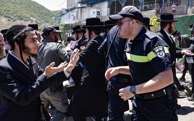 Ultra-Orthodox Jews scuffle with the police as they try to enter the gravesite of Rabbi Shimon Bar Yochai at Mount Meron, during the Lag B'Omer holiday that commemorates the 2nd-century Jewish scholar's death, May 19, 2022. (Menahem KAHANA / AFP)