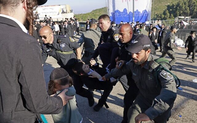 Israeli police detain an ultra-Orthodox Jewish youth outside the tomb of Rabbi Shimon Bar Yochai in Mount Meron during scuffles on the holiday of Lag B'Omer that commemorates the 2nd-century Jewish scholar's death, on May 19, 2022. (Menahem KAHANA / AFP)