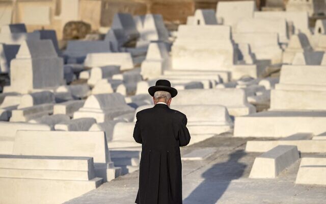A member of the Jewish community walks past graves at a Jewish cemetery in Morocco's northern city of Meknes on May 18, 2022. (FADEL SENNA / AFP)