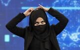 A female presenter for TOLOnews, Thamina Usmani, covers her face during a live broadcast at Tolo TV station in Kabul on May 22, 2022. (Wakil KOHSAR / AFP)