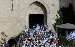 Jews taking part in the Flag March pass through the Damascus Gate to Jerusalem's Old City on May 29, 2022, as Israel marks Jerusalem Day. (Ahmad Gharabli/AFP)