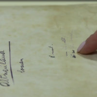 Susan Burns, curator at the Central Zionist Archives in Jerusalem points to the opening of Herzl's 'Altneuland,' on May 9, 2022. (Screen grab/Channel 13)