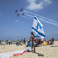 File: People at a beach in Tel Aviv watch a military airshow during Independence Day, May 2, 2017. (AP Photo/Dan Balilty)