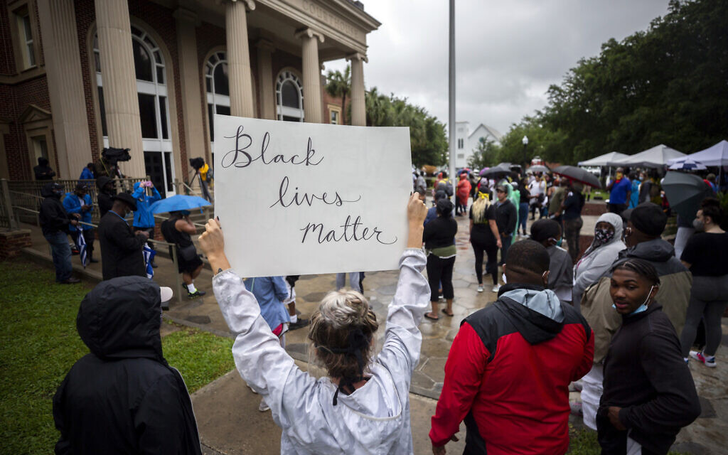 Protesters gather outside the courthouse during a preliminary hearing for Travis McMichael, Gregory McMichael and William Bryan, in Brunswick, Georgia, June 4, 2020. The three were accused of shooting of Ahmaud Arbery while he ran through their neighborhood. (AP Photo/ Stephen B. Morton, File)