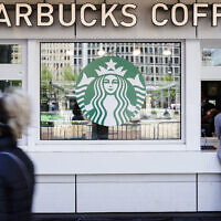 A customer makes a purchase at a a Starbucks coffee shop, in Philadelphia, April 26, 2021. (AP Photo/Matt Rourke)