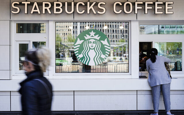 A customer makes a purchase at a a Starbucks coffee shop, in Philadelphia, April 26, 2021. (AP Photo/Matt Rourke)