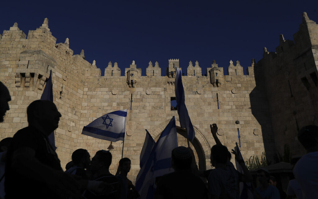Jewish nationalists wave Israeli flags during a Flag March next to the Damascus Gate, outside Jerusalem's Old City, June 15, 2021. (AP/Ariel Schalit)