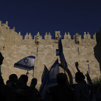 Jewish nationalists wave Israeli flags during the Flag March next to the Damascus gate, outside Jerusalem's Old City, Tuesday, June 15, 2021. (AP/Ariel Schalit)