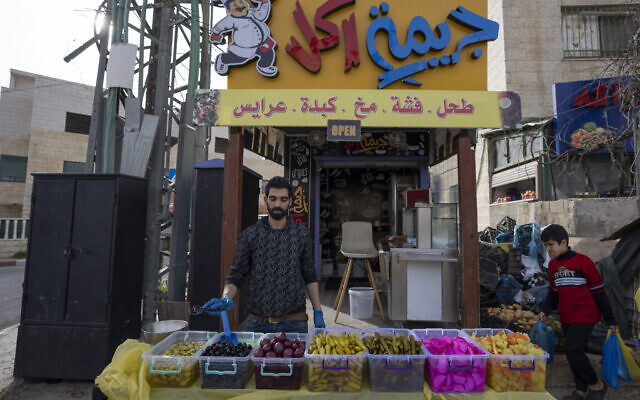 A Palestinian vendor displays a variety of pickles, widely desired as a side dish while breaking fast in Ramadan, in front of his cafeteria in the West Bank city of Ramallah, April 2, 2022.  (Nasser Nasser/AP)