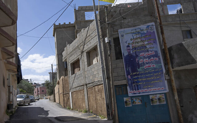 A banner celebrating Raad Hazem, a 28-year-old from the Jenin camp after he carried out a terror attack on a bar in central Tel Aviv,  in the West Bank refugee camp of Jenin, April 12, 2022. (AP Photo/Nasser Nasser)
