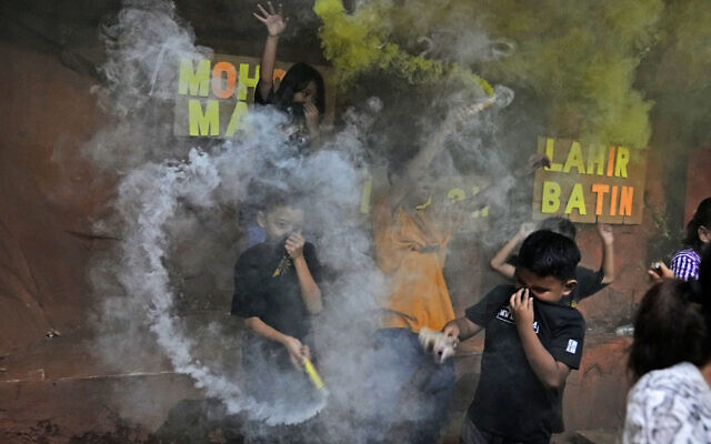 Young boys light smoke bombs as they celebrate the eve of Eid al-Fitr, the holiday marking the end of the holy fasting month of Ramadan, in Jakarta, Indonesia, May 1, 2022. (AP Photo/Dita Alangkara)