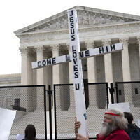 A demonstrator holding a cross protests outside of the U.S. Supreme Court, Washington DC, May 5, 2022. (AP/Jose Luis Magana, File)