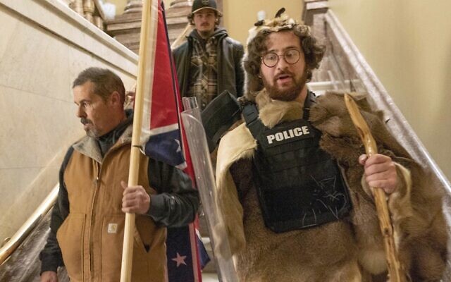 Supporters of President Donald Trump, including Aaron Mostofsky, right, who is identified in his arrest warrant, walk down the stairs outside the Senate Chamber in the US Capitol, in Washington, Jan. 6, 2021. (AP Photo/Manuel Balce Ceneta, File)