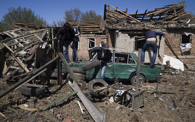 People clear a residential area after a Russian airstrike in Bakhmut, Donetsk region, Ukraine, on May 7, 2022. (AP Photo/Evgeniy Maloletka)