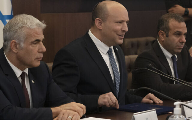 Prime Minister Naftali Bennett, center, makes a statement at the start of the weekly cabinet meeting seated next to Foreign Minister Yair Lapid, left, in Jerusalem, Sunday, May 8, 2022. (AP Photo/Maya Alleruzzo, Pool)
