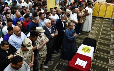Men pray in front of the coffin of military solider Ahmed Mohamed Ahmed Ali, who was killed in battle, during his funeral service, in Qalyubia province, Egypt, May 8, 2022. At least 11 Egyptian troops, including an officer, were killed May 7, 2022 in a militant attack on a water pumping station east of the Suez Canal, the military said. (AP Photo/Sayed Hassan)
