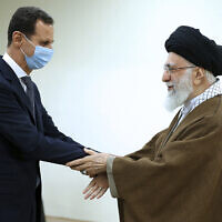 In this picture released by the official website of the office of the Iranian supreme leader, Supreme Leader Ayatollah Ali Khamenei, right, and Syrian President Bashar Assad shake hands at the start of their meeting, in Tehran, Iran, May 8, 2022. (Office of the Iranian Supreme Leader via AP)
