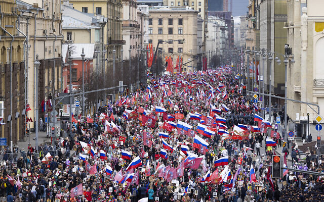 People attend the Immortal Regiment march through the main street toward Red Square marking the 77th anniversary of the end of World War II, in Moscow, Russia, Monday, May 9, 2022. (AP Photo/Denis Tyrin)