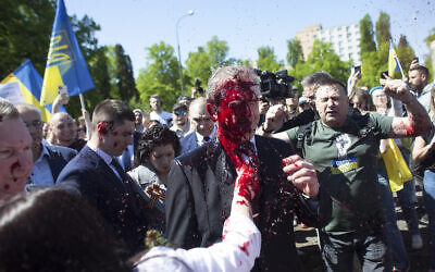Russian Ambassador to Poland Sergey Andreev is covered with red paint in Warsaw, Poland, May 9, 2022. (AP Photo/Maciek Luczniewski)